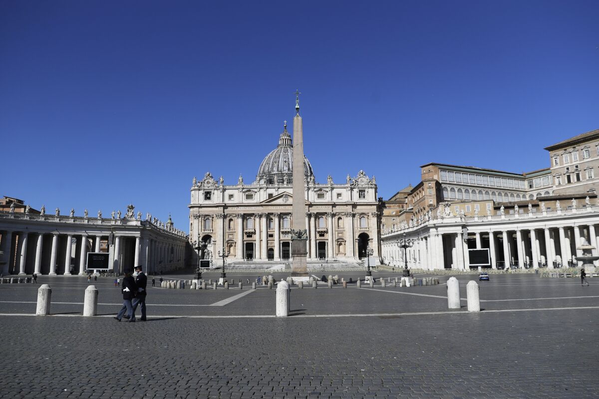 FILE - Policemen patrol an empty St. Peter's Square at the Vatican, Sunday, April 4, 2021. One of the principal figures in the Vatican’s bungled London real estate venture testified Monday, June 6, 2022 that the Holy See would have turned a profit on its valuable investment if it hadn’t pulled its money out of a fund prematurely, blaming “irrational” decisions by a client that should have known better. (AP Photo/Gregorio Borgia, File)