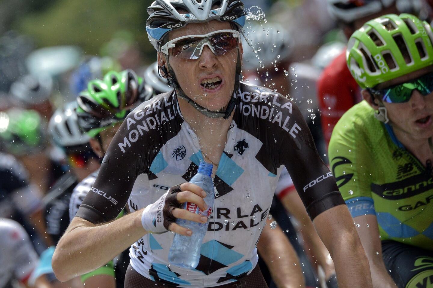 France's Romain Bardet sprays water on his face Thurdsday as he rides to victory in Stage 18 of the Tour de France, between Mende and Valence.