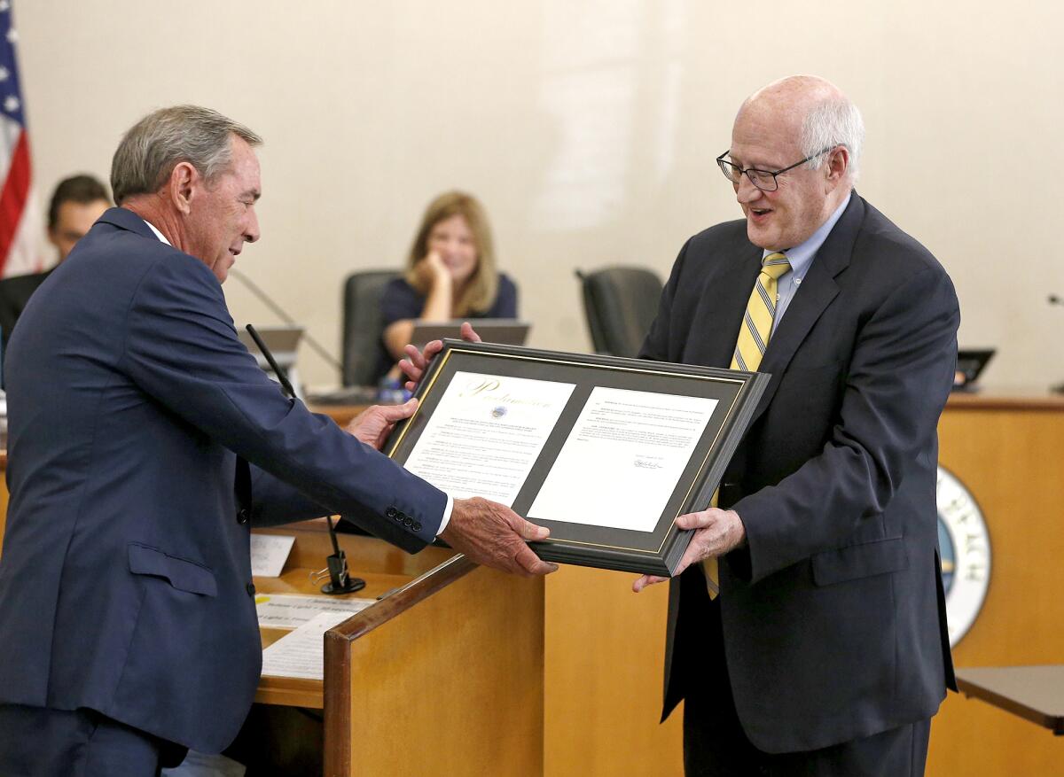 Laguna Beach Mayor Bob Whalen hands City Atty. Phil Kohn a proclamation.