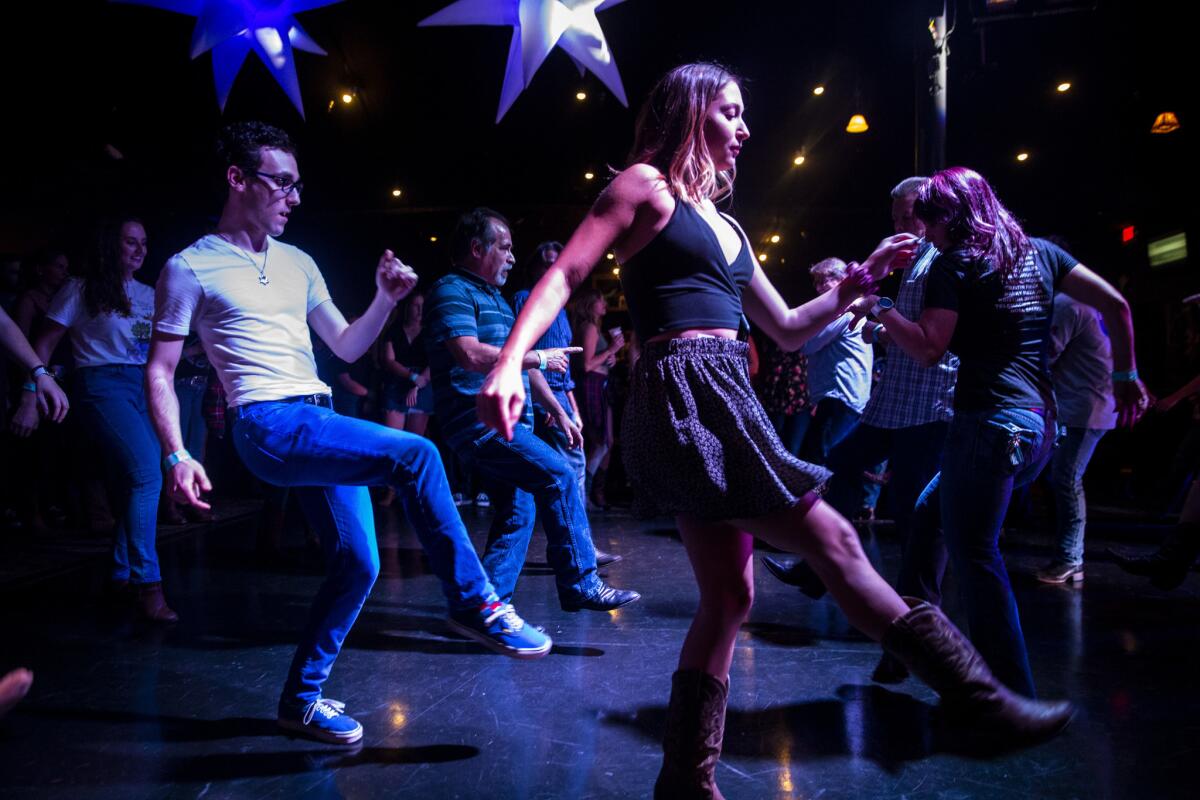 Ben Ginsburg, 23, of Woodland Hills and Kylie Rice, 19, of Simi Valley dance at Borderline Country Night at The Canyon bar. On Thursday, more than a thousand people — including many survivors — gathered for the first night of line dancing since the Borderline bar closed.