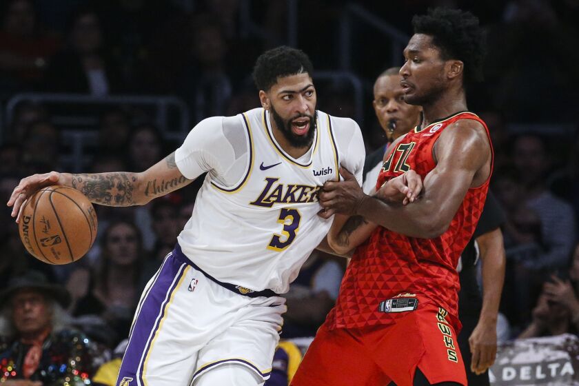 Los Angeles Lakers' Anthony Davis (3) dribbles against Atlanta Hawks's Damian Jones (30) during the second half of an NBA basketball game, Sunday, Nov. 17, 2019, in Los Angeles. The Lakers won 122-101. (AP Photo/Ringo H.W. Chiu)