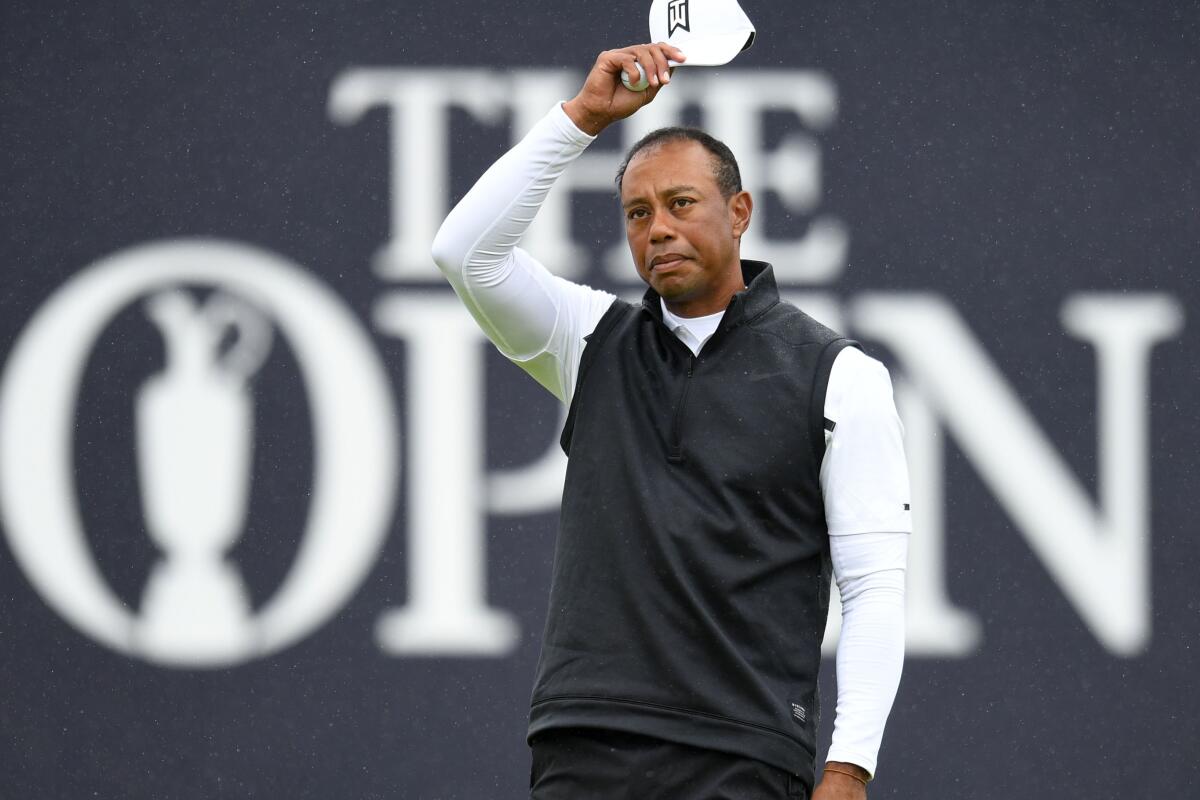 Tiger Woods acknowledges his fans at the 18th hole.