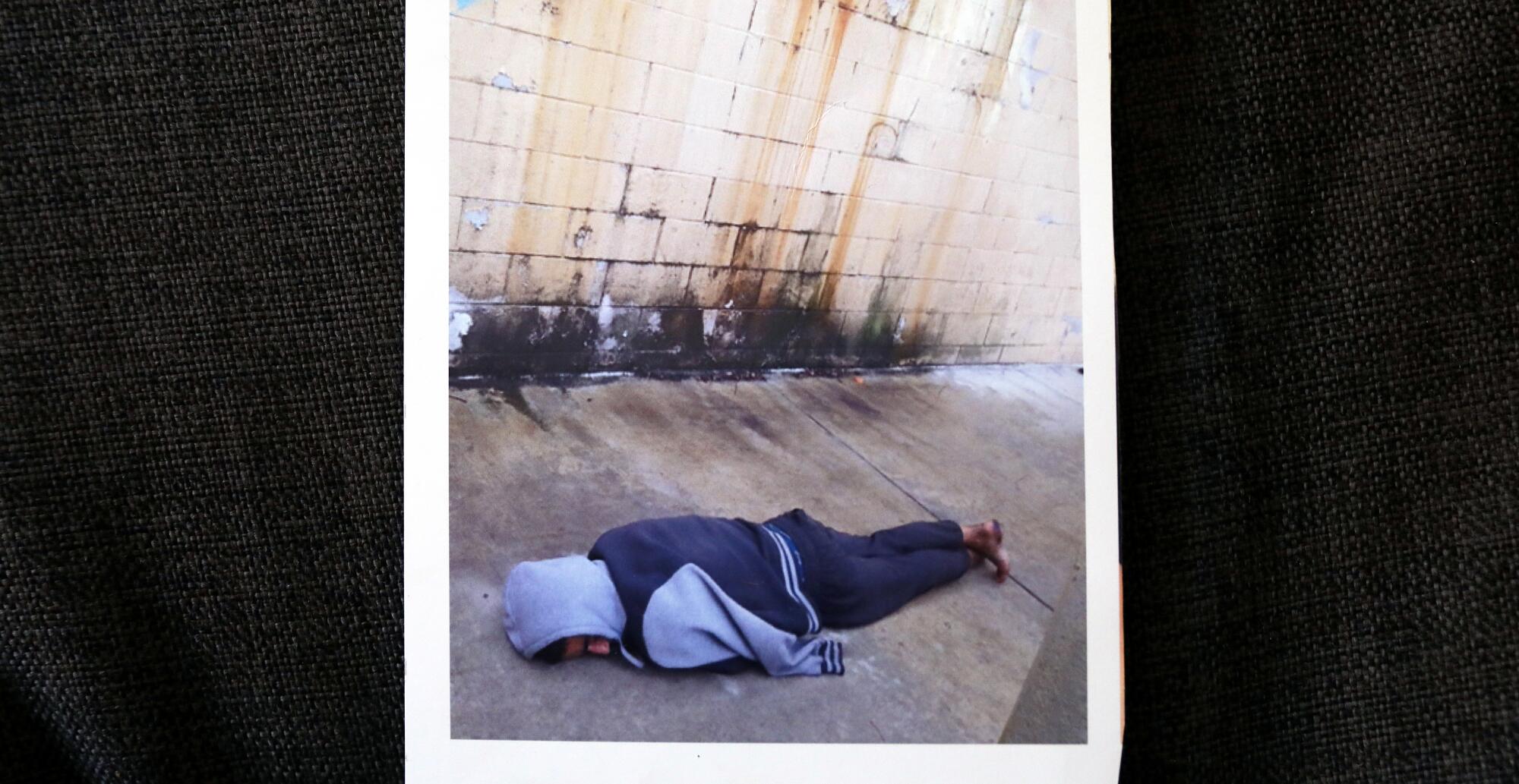 A man lies on the sidewalk.