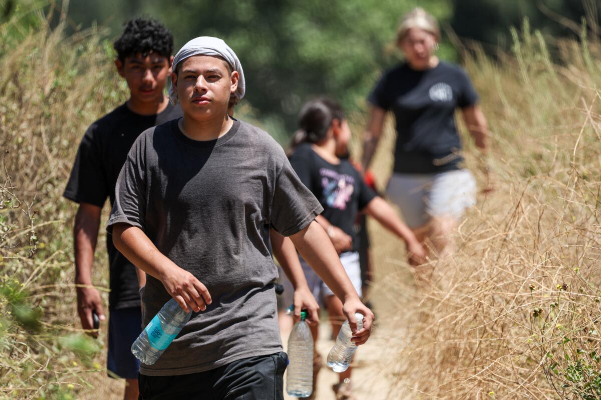 Hikers walk a trail on a hot day