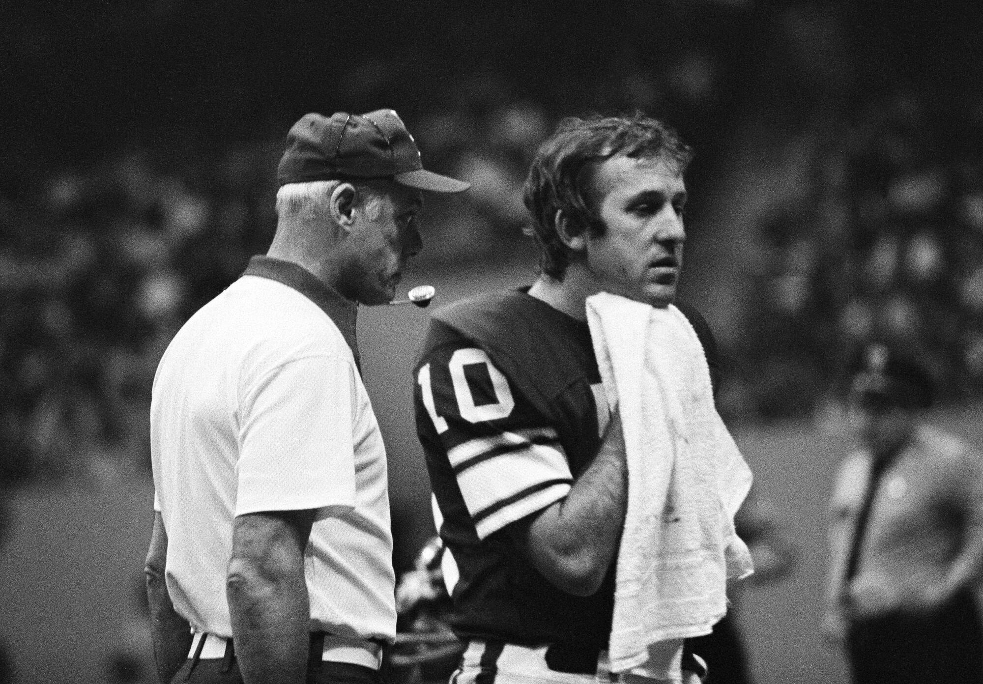 Vikings quarterback Fran Tarkenton talks with coach Bud Grant in 1975.
