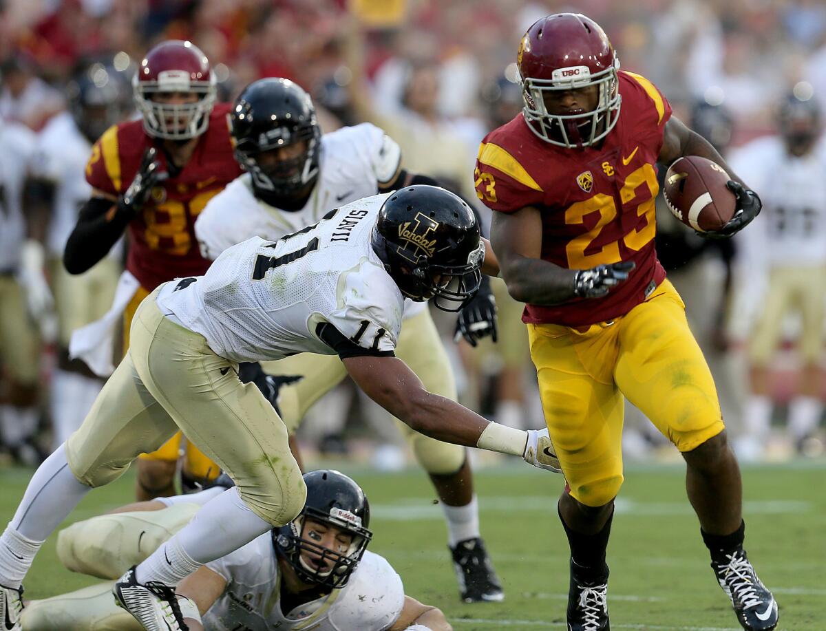 USC tailback Tre Madden eludes a tackle by Idaho strong safety Russell Siavii on the way to a touchdown in the second quarter Saturday at the Coliseum.