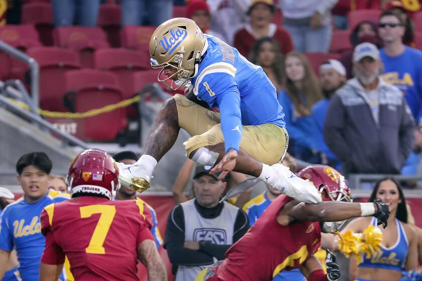 Los Angeles, CA - November 20: UCLA quarterback Dorian Thompson-Robinson hurdles high.