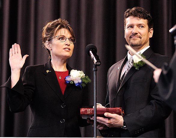 Todd Palin holds the Bible for his wife, Sarah, as she is sworn in as Alaska's governor during an inauguration ceremony in Fairbanks in December 2006.