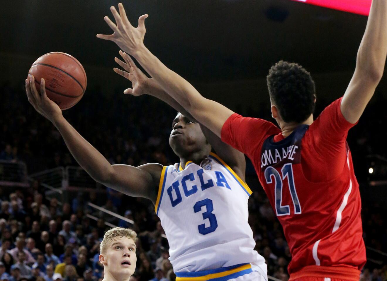 UCLA guard Aaron Holiday drives to the basket against Arizona center Chance Comanche during the second half.