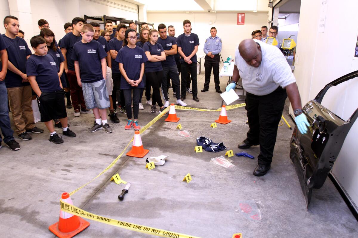 Glendale Police Dept. Forensics expert Allan Brogdon, right, shows teen academy participants a mock crime scene during class at Glendale police headquarters on Wednesday, June 29, 2016.