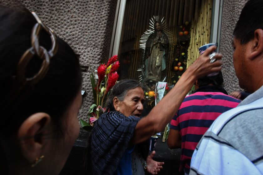 A woman prays over pilgrims at the Basilica of Our Lady of Guadalupe in Mexico City in 2013. The shrine is where Pope Francis will celebrate Mass on Feb. 13, 2016.