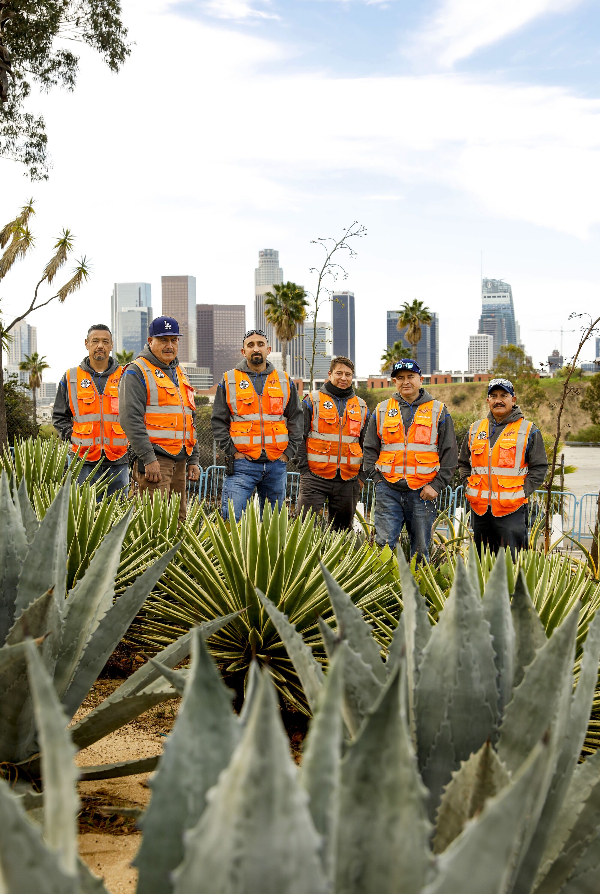 Chaz Perea and his landscaping team stand among 22 varieties of agaves with downtown L.A. in the background.
