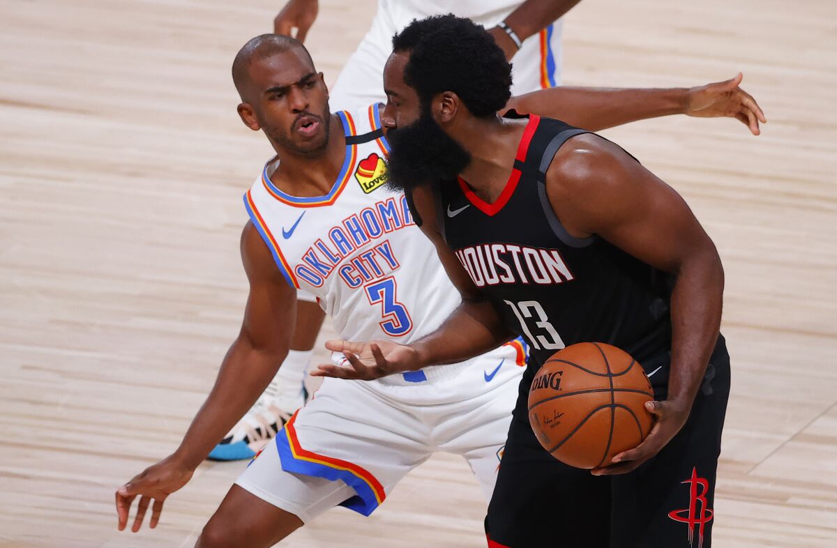 Thunder guard Chris Paul plays tight defense on former teammate and Rockets star James Harden.