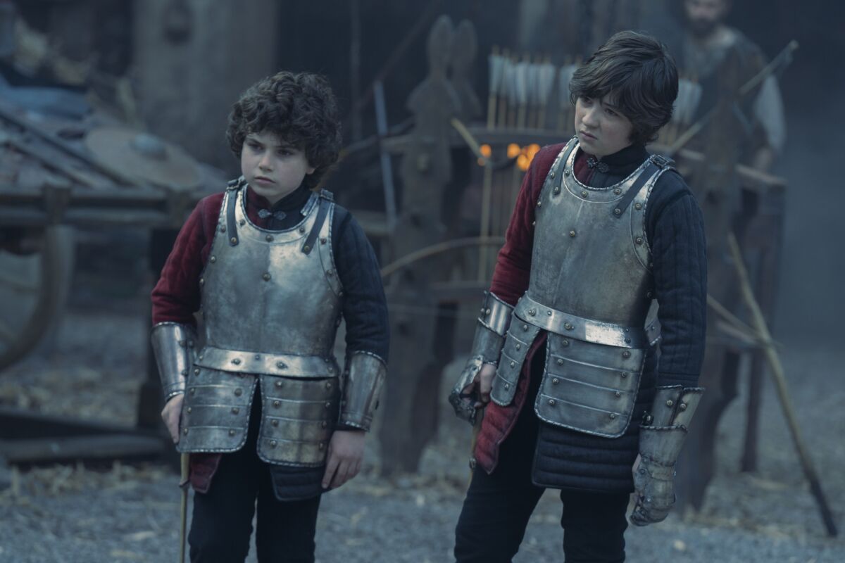 two boys in armor standing next to each other