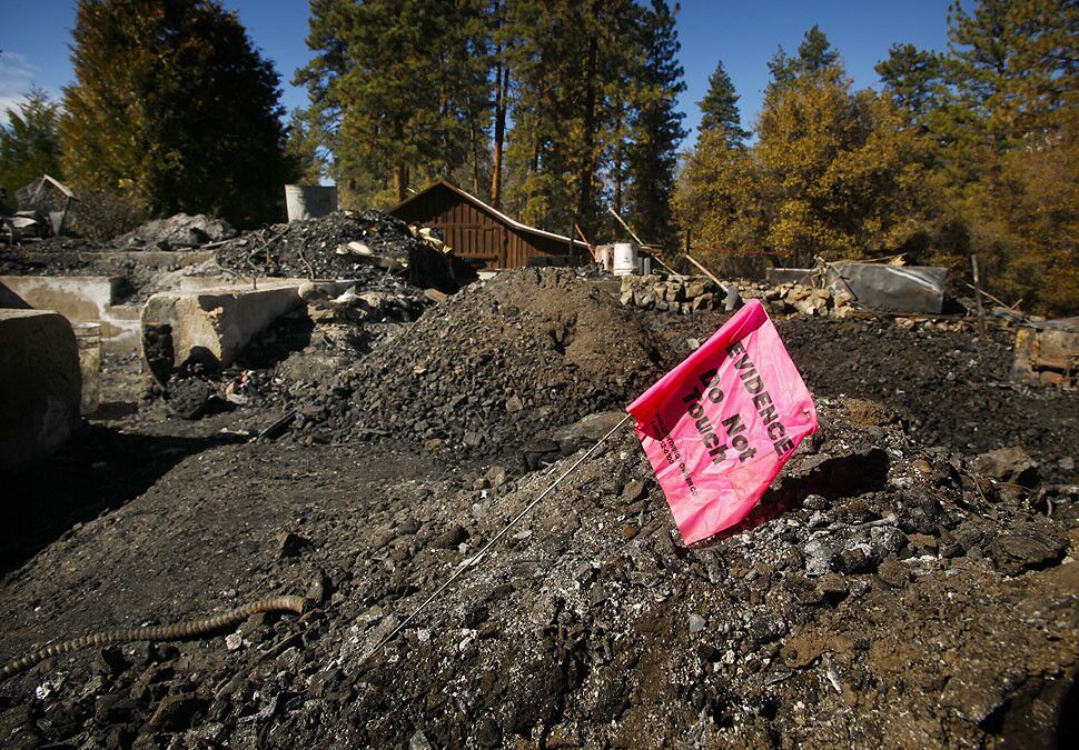 Evidence tags are still posted in the charred debris at the cabin on Seven Oaks Road in Angelus Oaks.