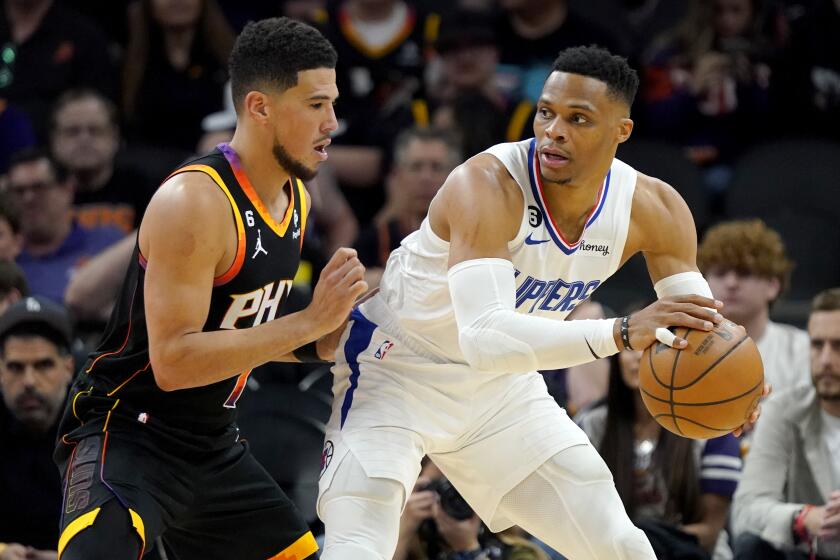 Los Angeles Clippers guard Russell Westbrook backs down Phoenix Suns guard Devin Booker.