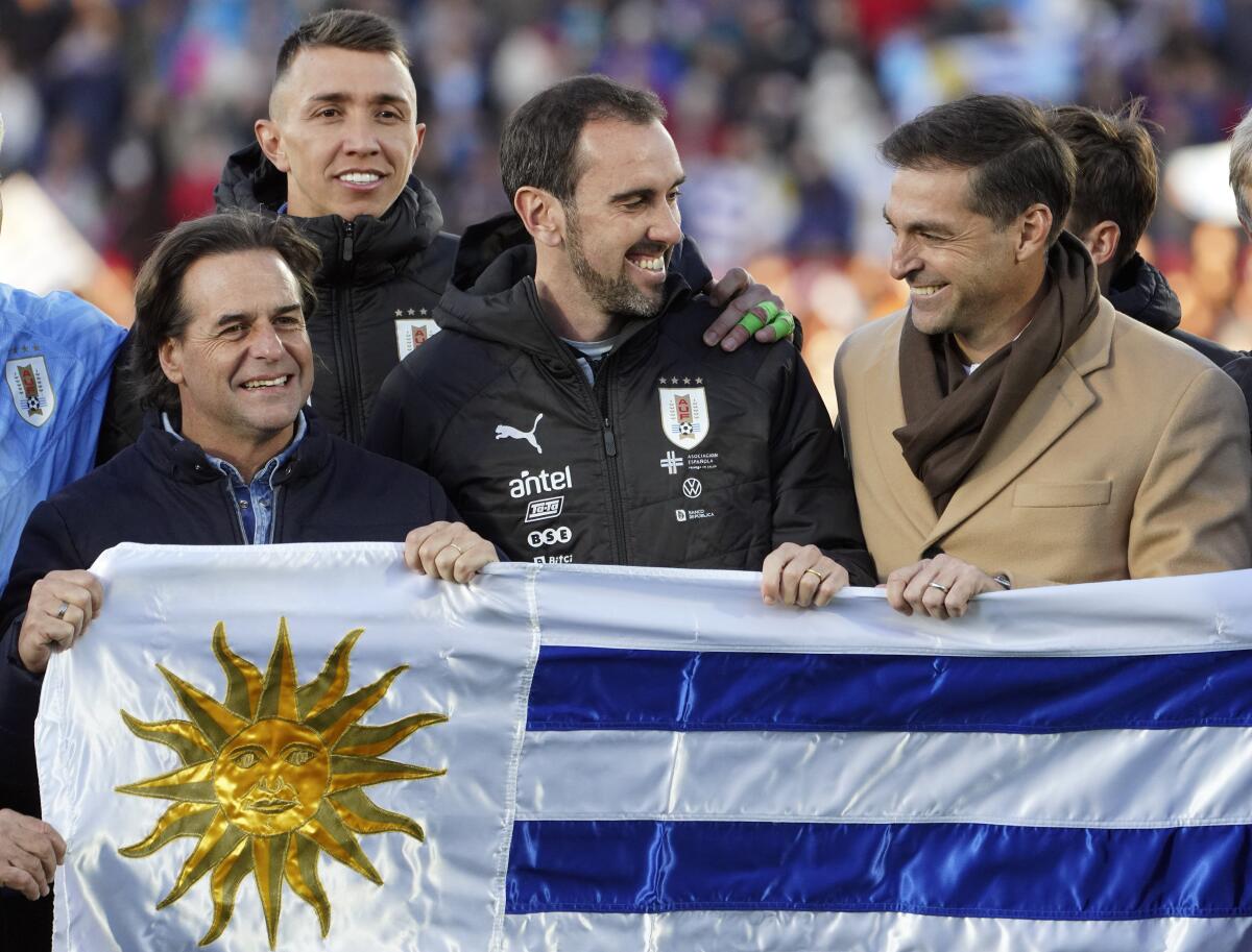 El presidente de Uruguay Luis Lacalle (izquierda) y los jugadores Fernando Muslera y Diego Godín
