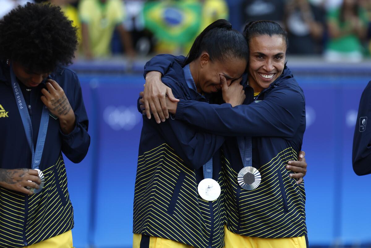 Brazil's Marta consoles a teammate during the medal ceremony after losing to the U.S. during the gold-medal match