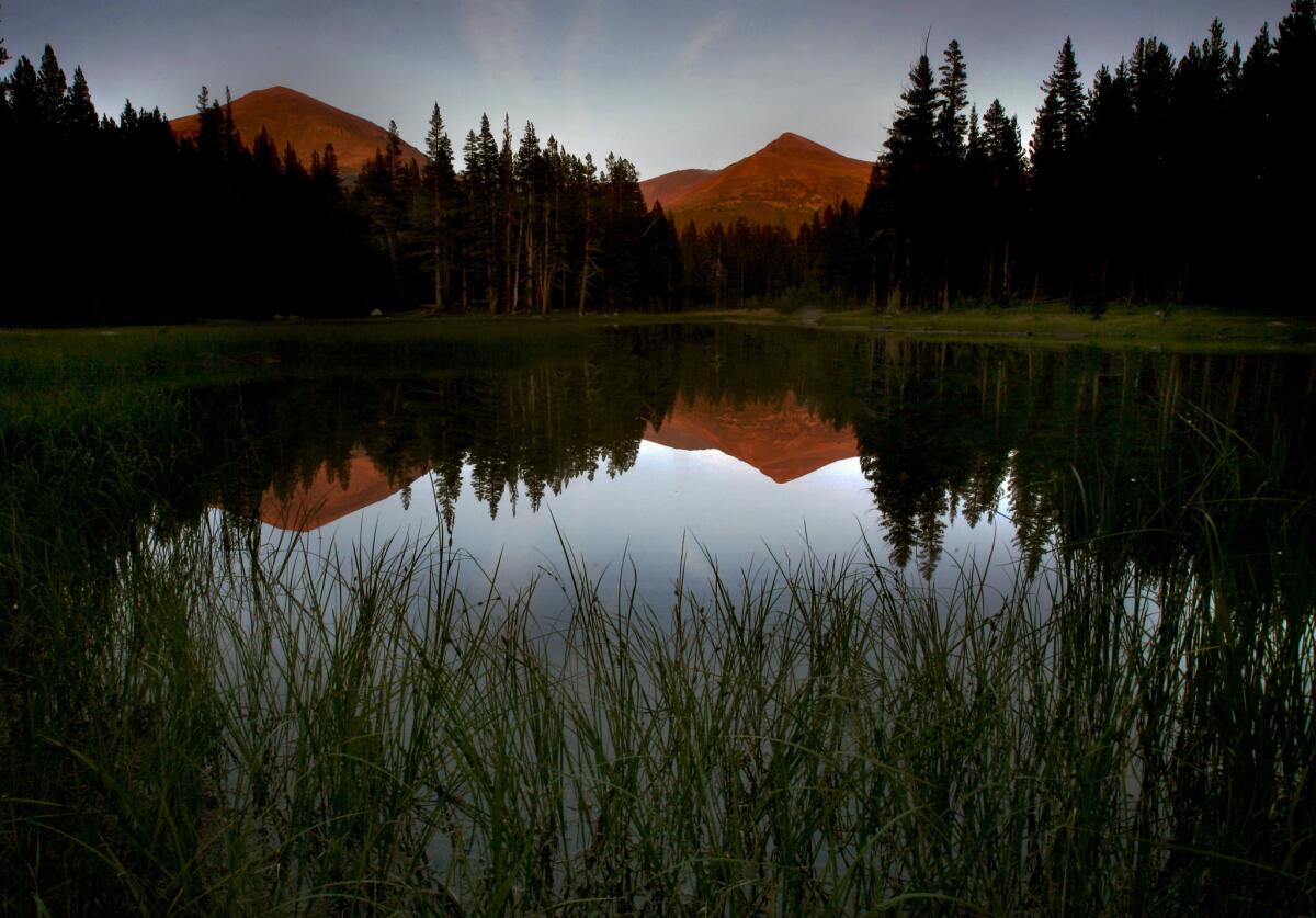 Mount Gibbs, left, and Mount Dana are reflected in a lake in Tuolumne Meadows in Yosemite National Park. The park has been closed by the government shutdown that started Tuesday.