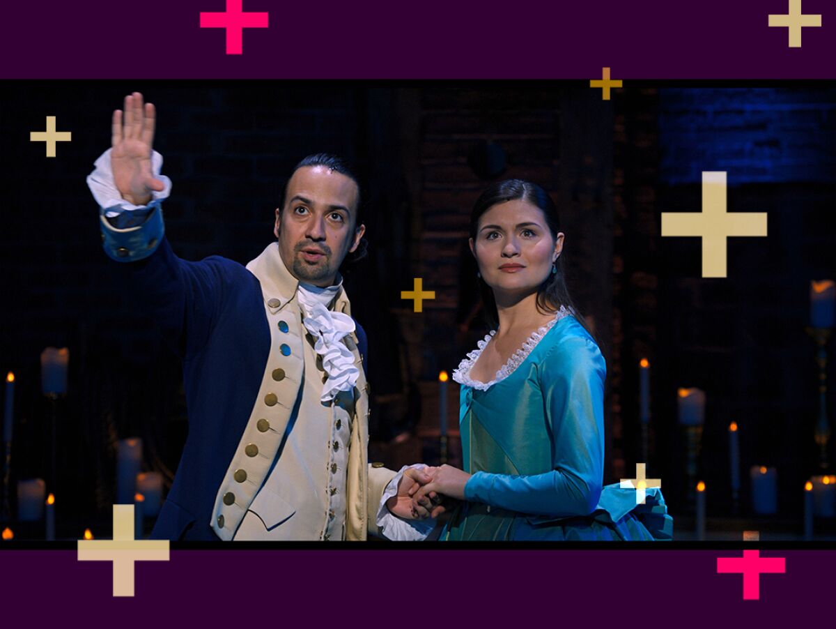 Lin Manuel Miranda gestures outward while holding Phillipa Soo's hand in a scene from "Hamilton."