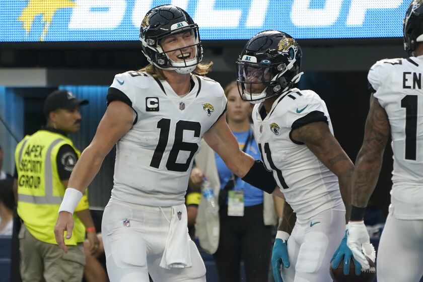 Jacksonville Jaguars quarterback Trevor Lawrence (16) and wide receiver Marvin Jones Jr. celebrate after connecting on a touchdown pass during the second half of an NFL football game against the Los Angeles Chargers in Inglewood, Calif., Sunday, Sept. 25, 2022. (AP Photo/Marcio Jose Sanchez)