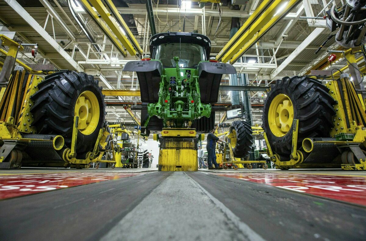 FILE - In this April 9, 2019, wheels are attach as workers assemble a tractor at John Deere's Waterloo, Iowa assembly plant. The vast majority of United Auto Workers union members rejected a contract offer from Deere & Co. Sunday, Oct. 10, 2021 that would have delivered at least 5% raises to the workers who make John Deere tractors and other equipment. (Zach Boyden-Holmes/Telegraph Herald via AP, File)