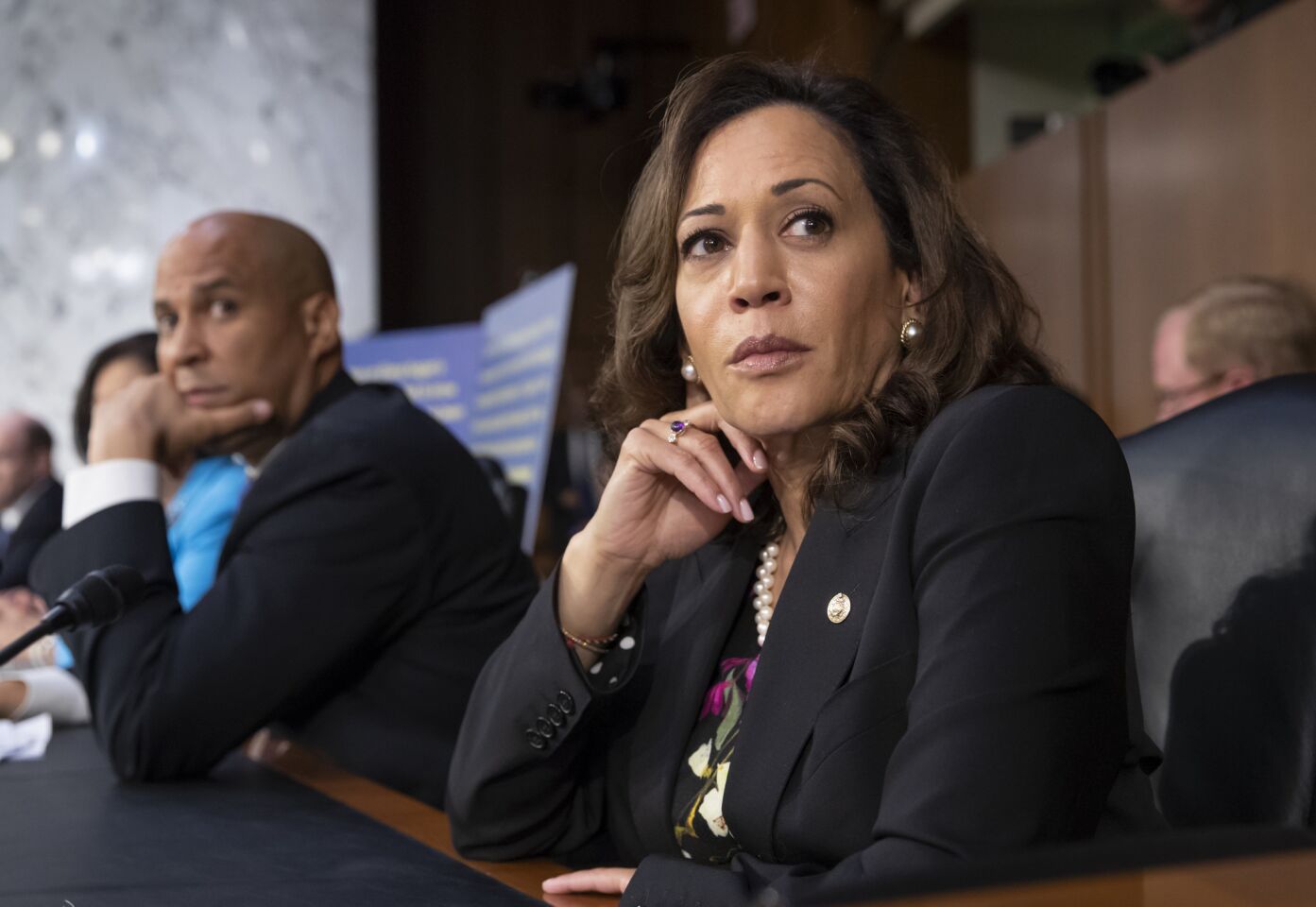 Sens. Kamala Harris (D-Calif.) and Cory Booker (D-N.J.) pause as protesters disrupt the confirmation hearing of President Trump's Supreme Court nominee, Brett Kavanaugh.