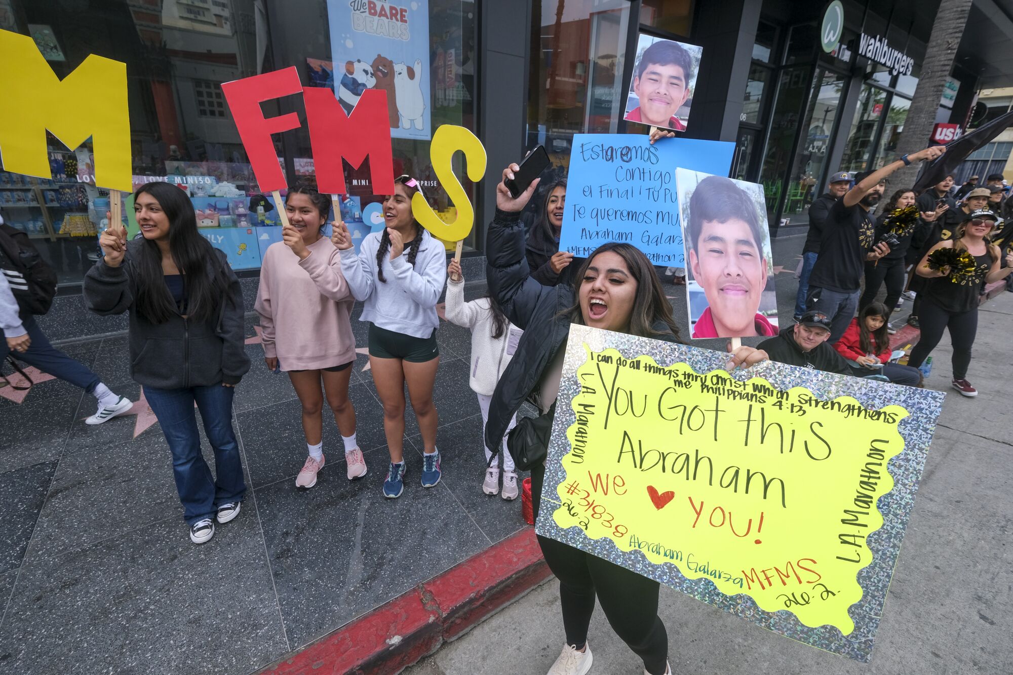 Fans cheer and hold signs on Hollywood Boulevard during the 38th LA Marathon.