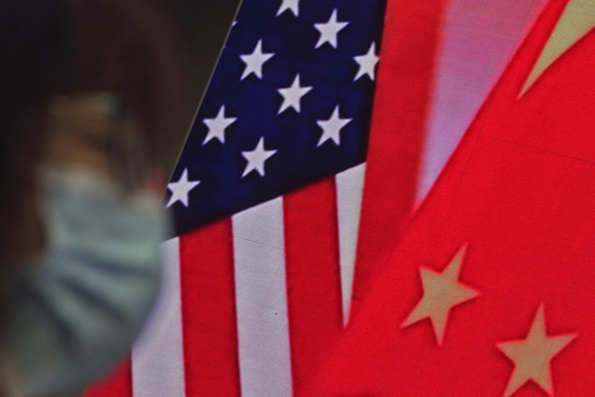 The flags of China and the United States can be seen together on a screen in Beijing on Feb. 22.