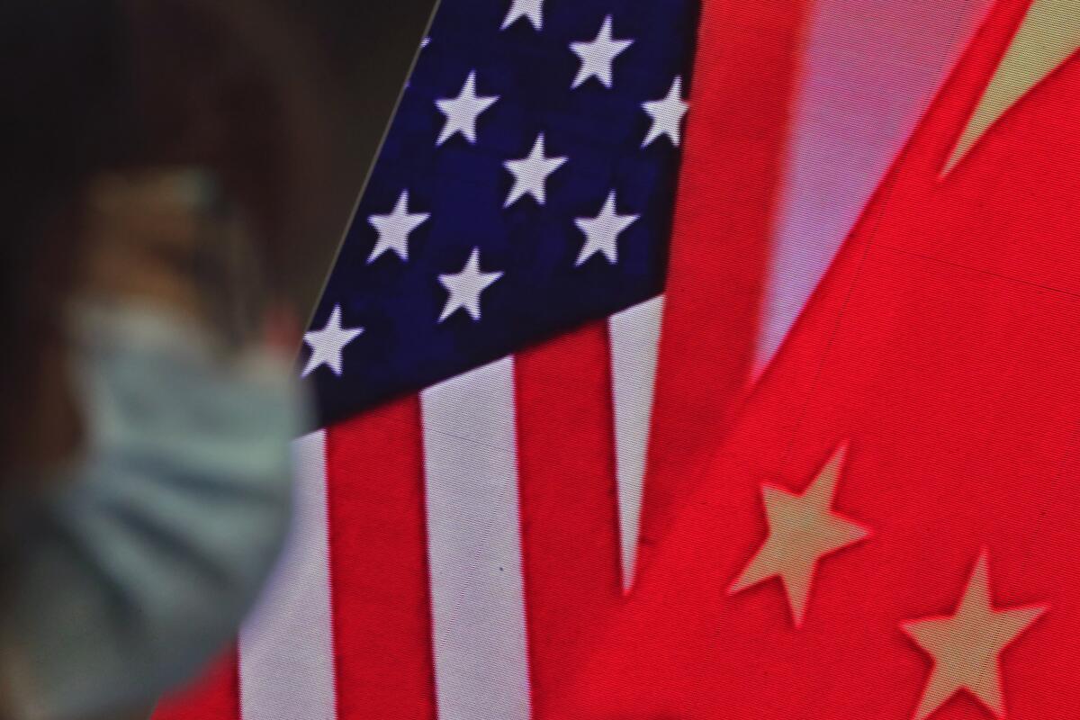 The flags of China and the United States can be seen together on a screen in Beijing on Feb. 22. 