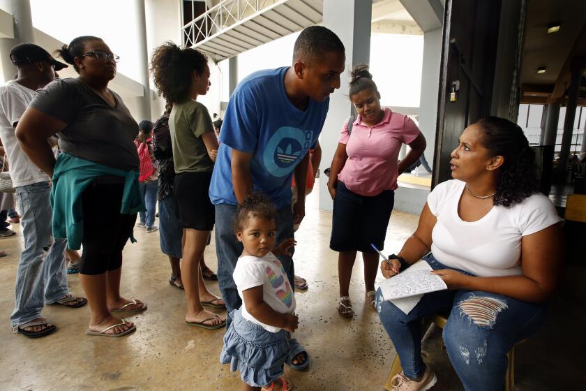 Jason Castro his daughter Hennessey Castro, age 2, receive FEMA food aid in Rio Grande, Puerto Rico.