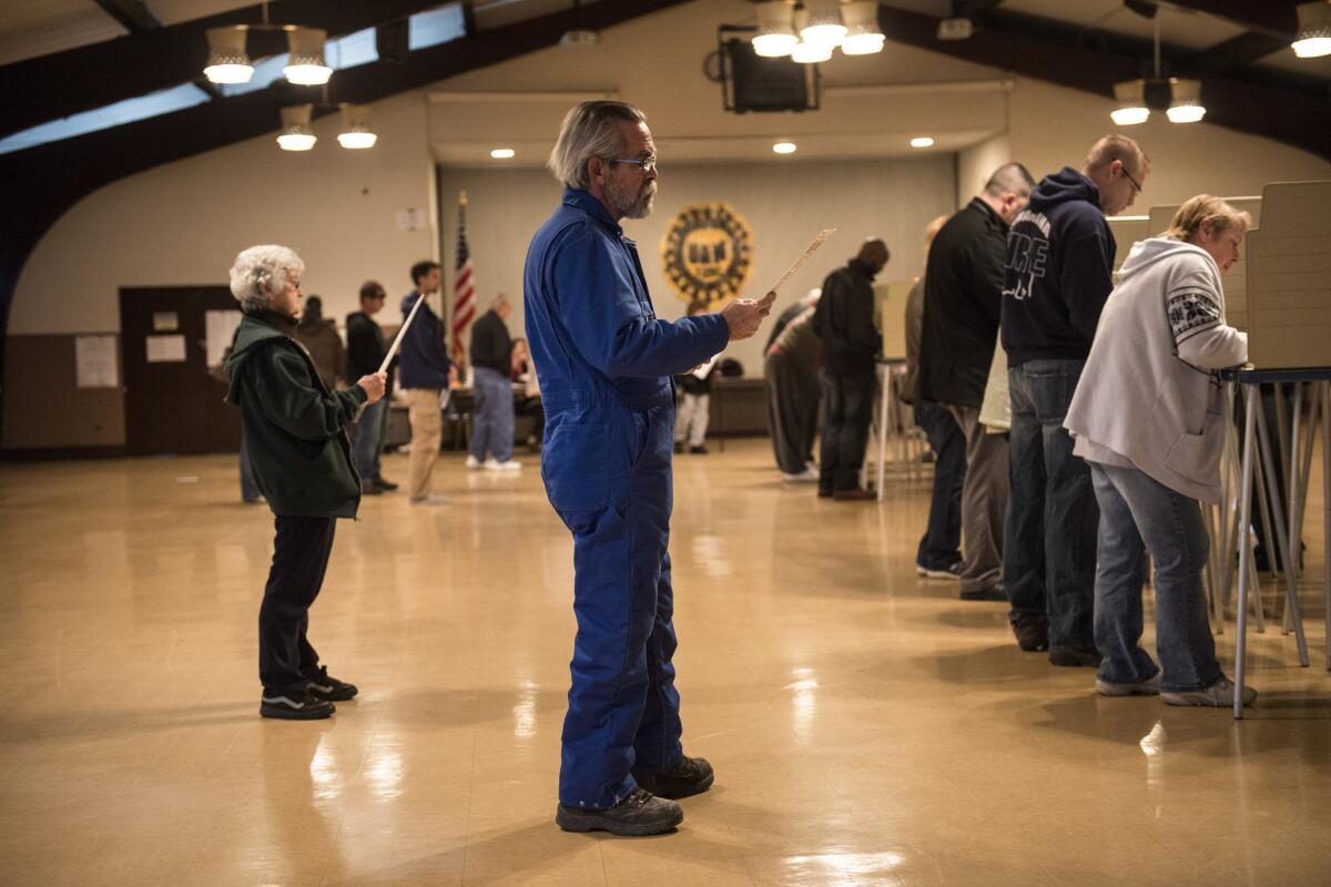 People wait their turn as others vote at the United Auto Workers Local 1250 on Tuesday in Cleveland.