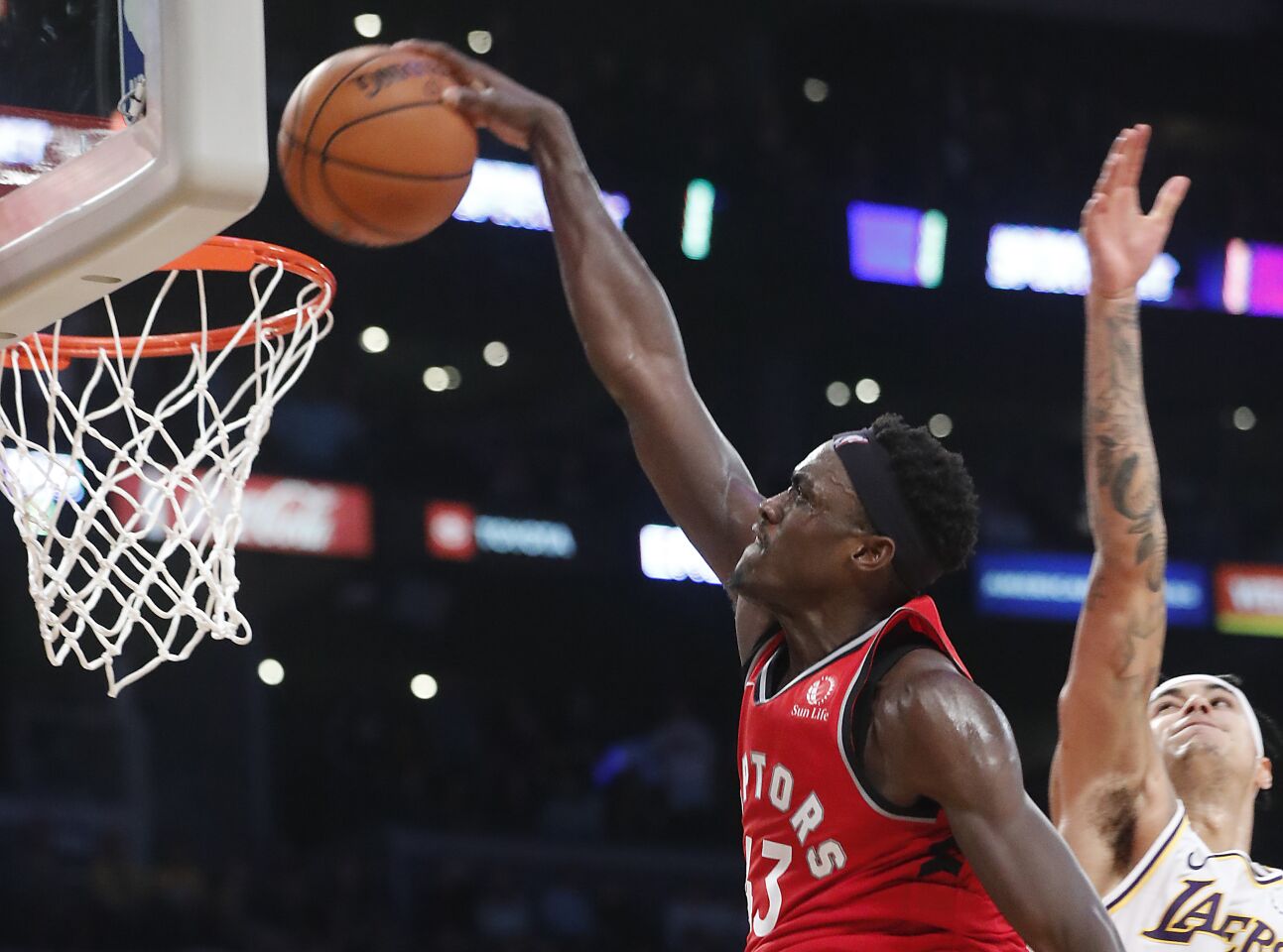 Raptors forward Pascal Siakam gets past Lakers forward Kyle Kuzma for a dunk during the fourth quarter.