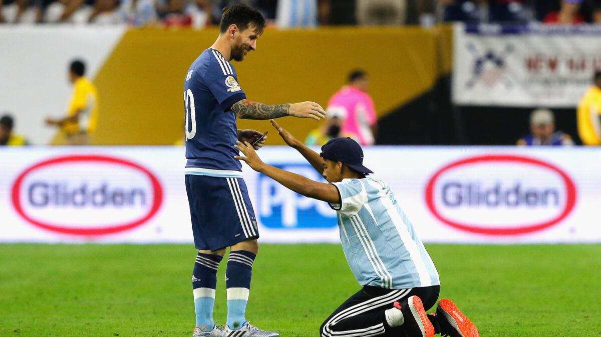 Lionel Messi with a fan who ran onto the field before start of the second half of a game.