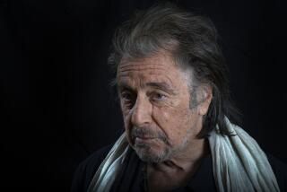 Al Pacino wearing a scarf  posing somberly against a black background