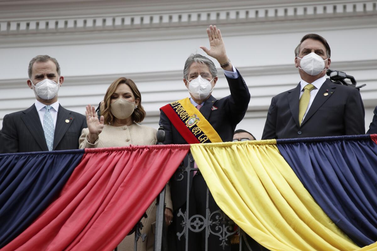 Ecuador's new President Guillermo Lasso, with others, waving from balcony