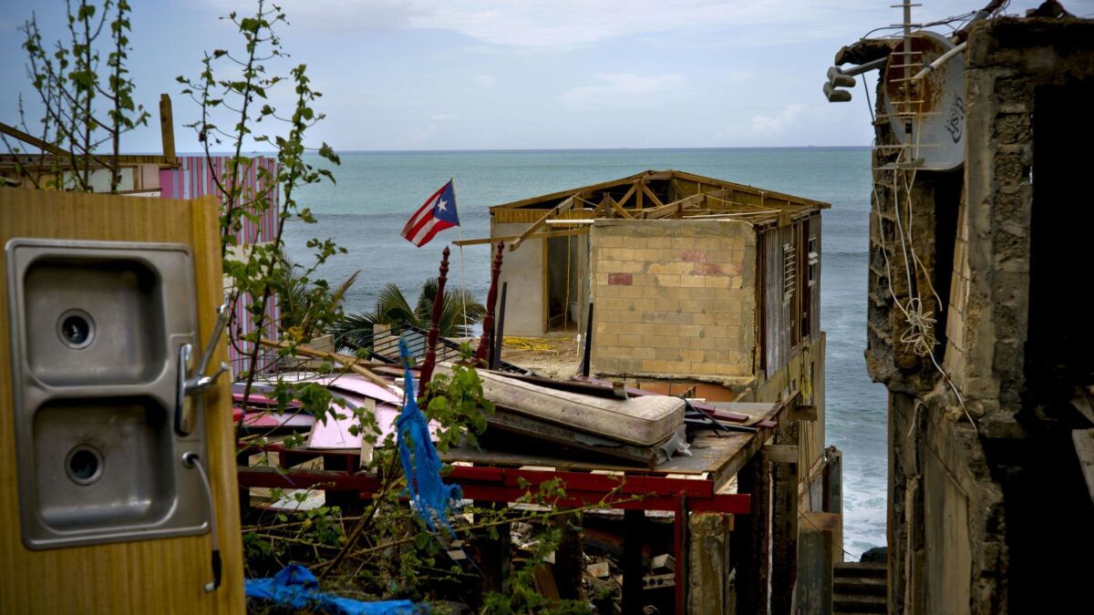 A Puerto Rican national flag is mounted on debris of a damaged home in the aftermath of Hurricane Maria in the seaside slum La Perla, San Juan, Puerto Rico, on Oct. 5, 2017.