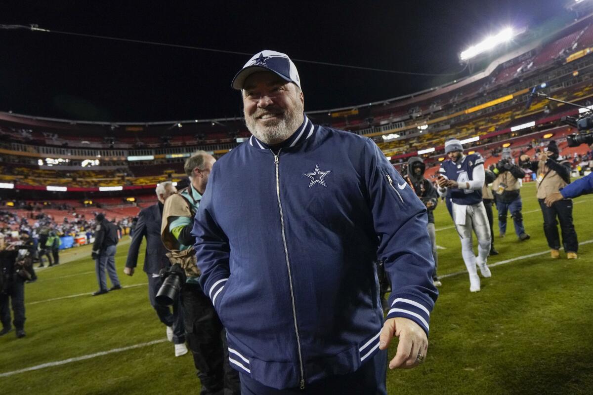 Dallas Cowboys coach Mike McCarthy smiles as he walks off the field following a win over the Washington Commanders on Sunday.