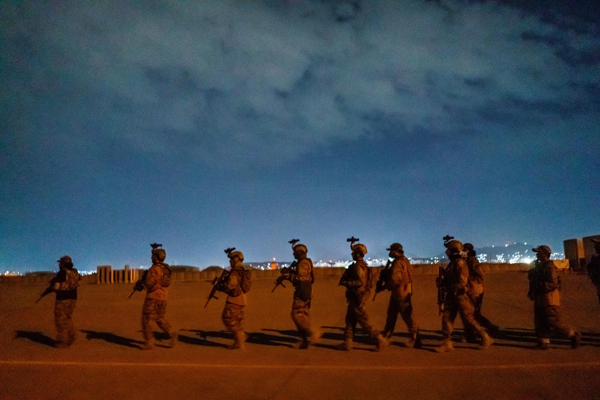 Taliban fighters walk in a line