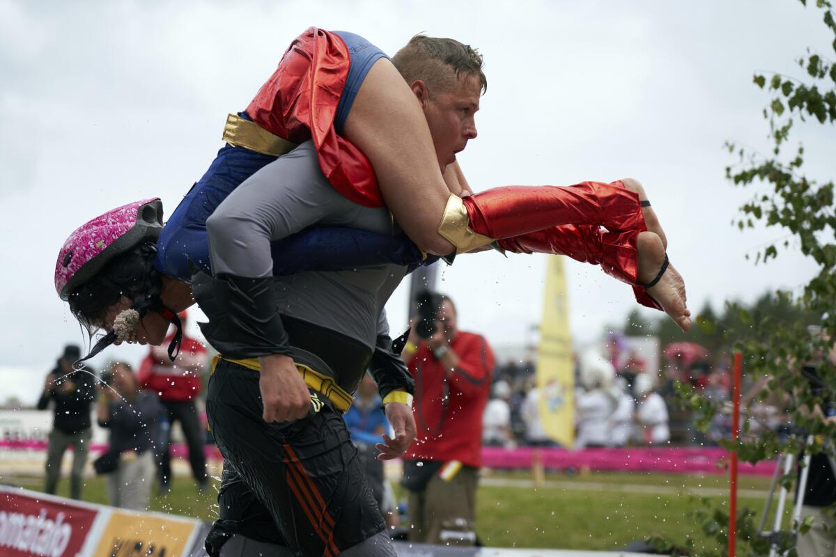 Participantes del campeonato mundial de “cargando a la esposa” en Sonkajarvi, Finlandia.