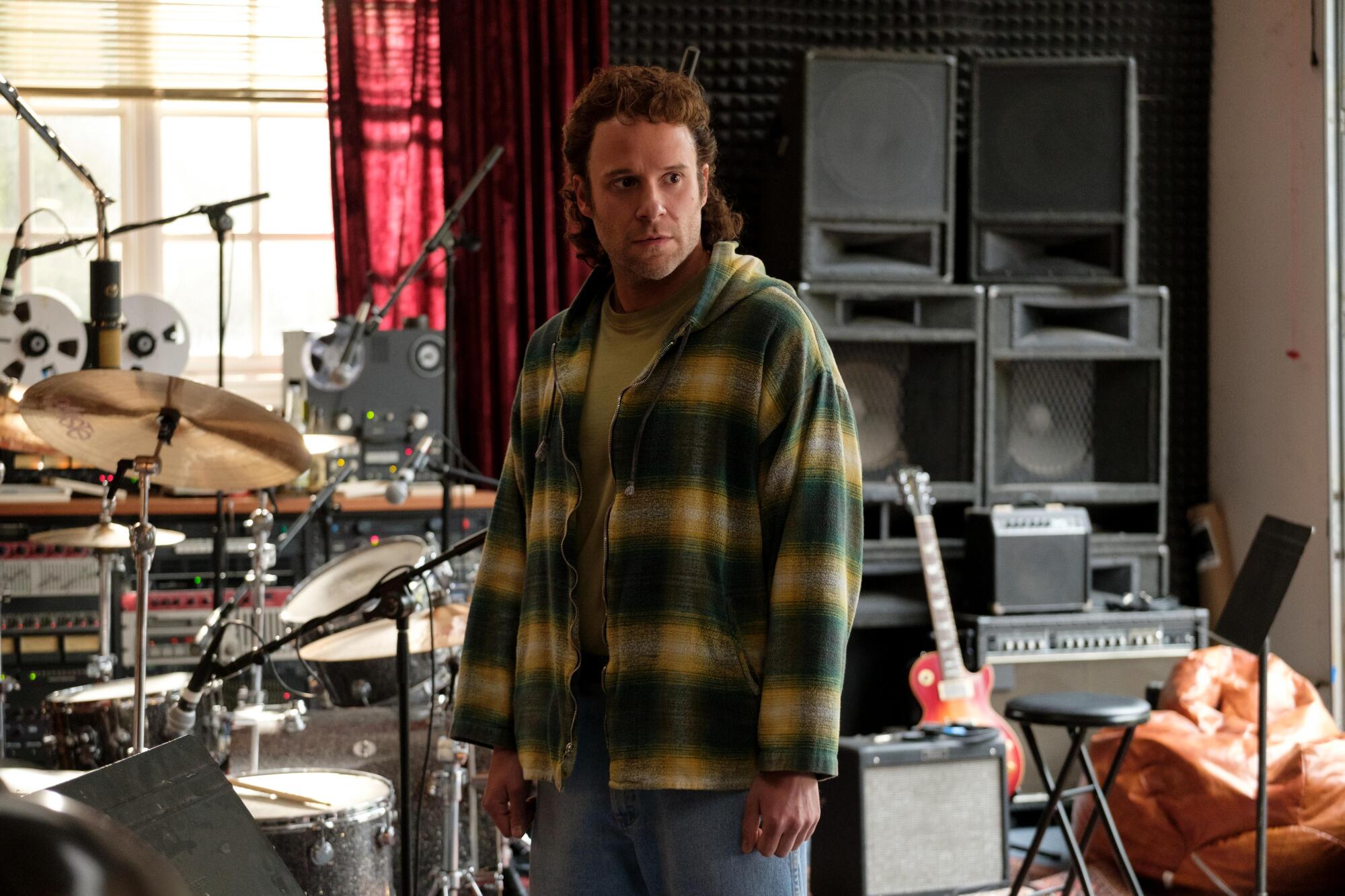 A man stands in a home music studio.