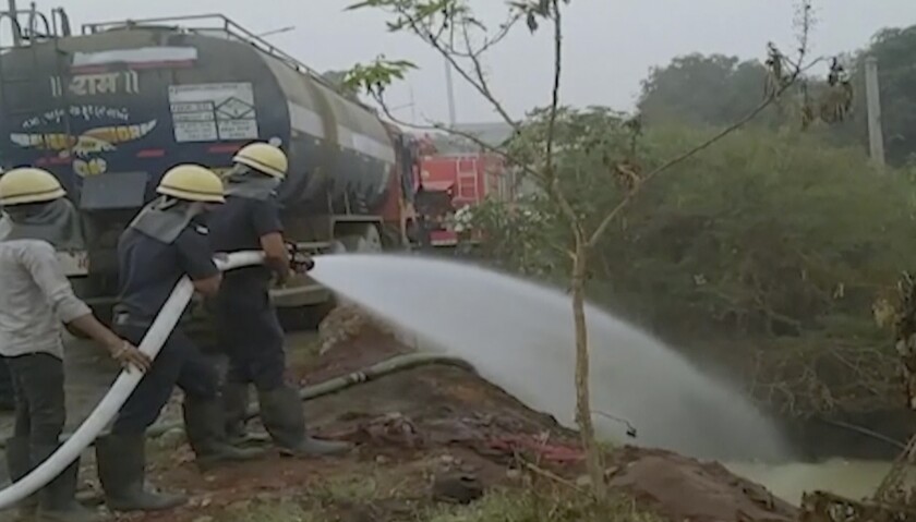 This image from video shows firefighters spray water following gas leak from an industrial tanker at an industrial complex in Surat, Gujarat state, India, Thursday, Jan.6, 2022. Police say at least six people were killed another 25 people were hospitalized. (K K Productions via AP)