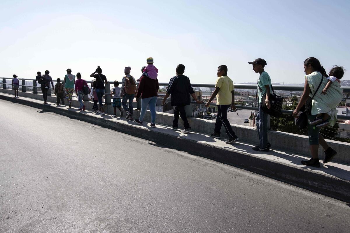 Central American asylum seekers walk to their legal counsel meetings in Tijuana.