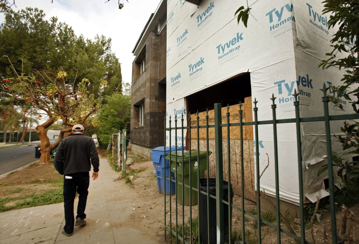 Bill Cohen walks past a large home under construction in his neighborhood near the Westside. Some believe the "mansionization" trend is being fueled by loopholes in L.A.'s building codes.
