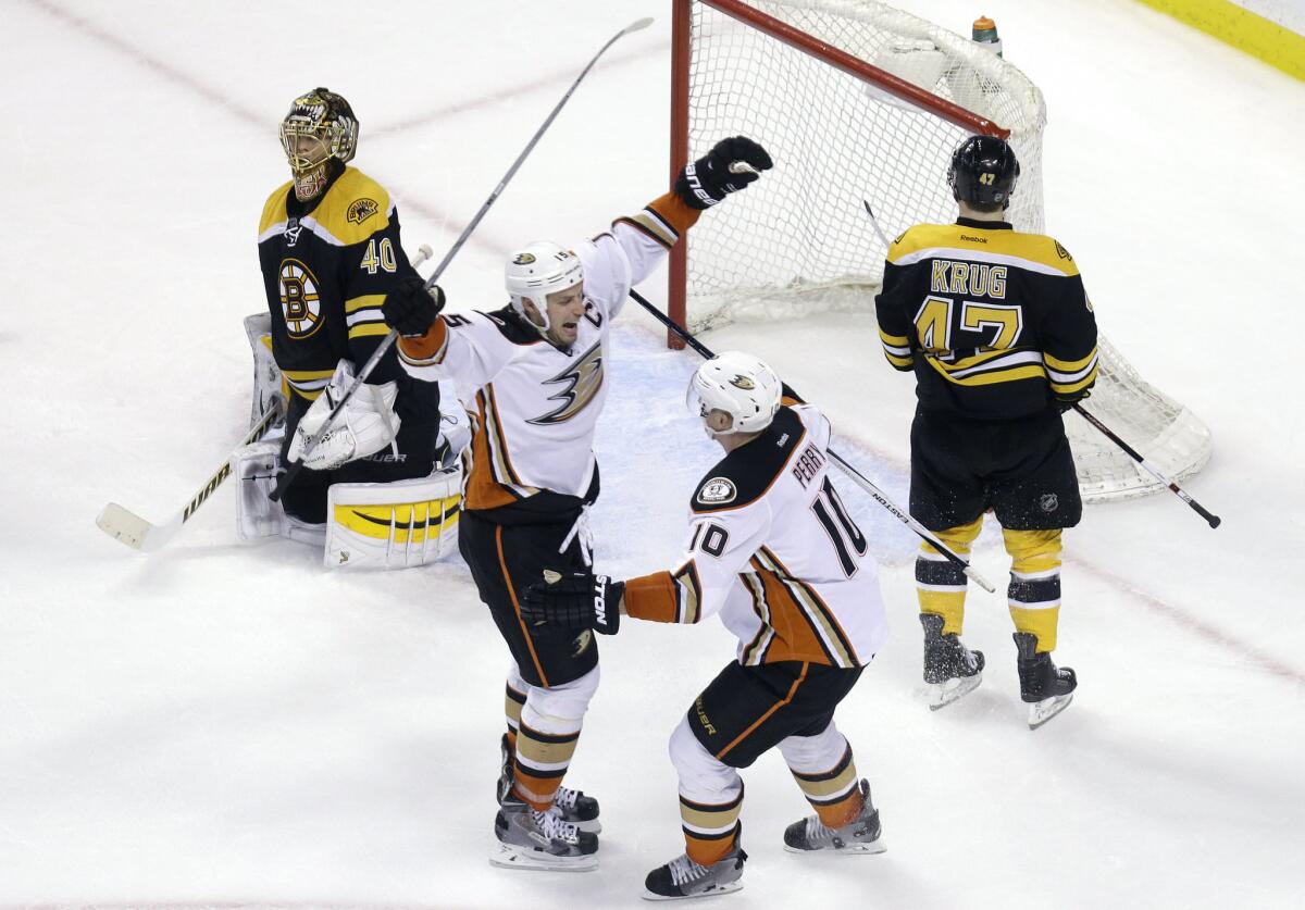 Ducks center Ryan Getzlaf, left, celebrates his winning goal in overtime with teammate Corey Perry (10) as Bruins goalie Tuukka Rask (40) and defenseman Torey Krug (47) react.