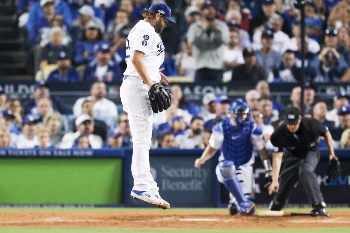 Dodgers starting pitcher Clayton Kershaw jumps after giving up a run-scoring double to San Diego's Manny Machado.