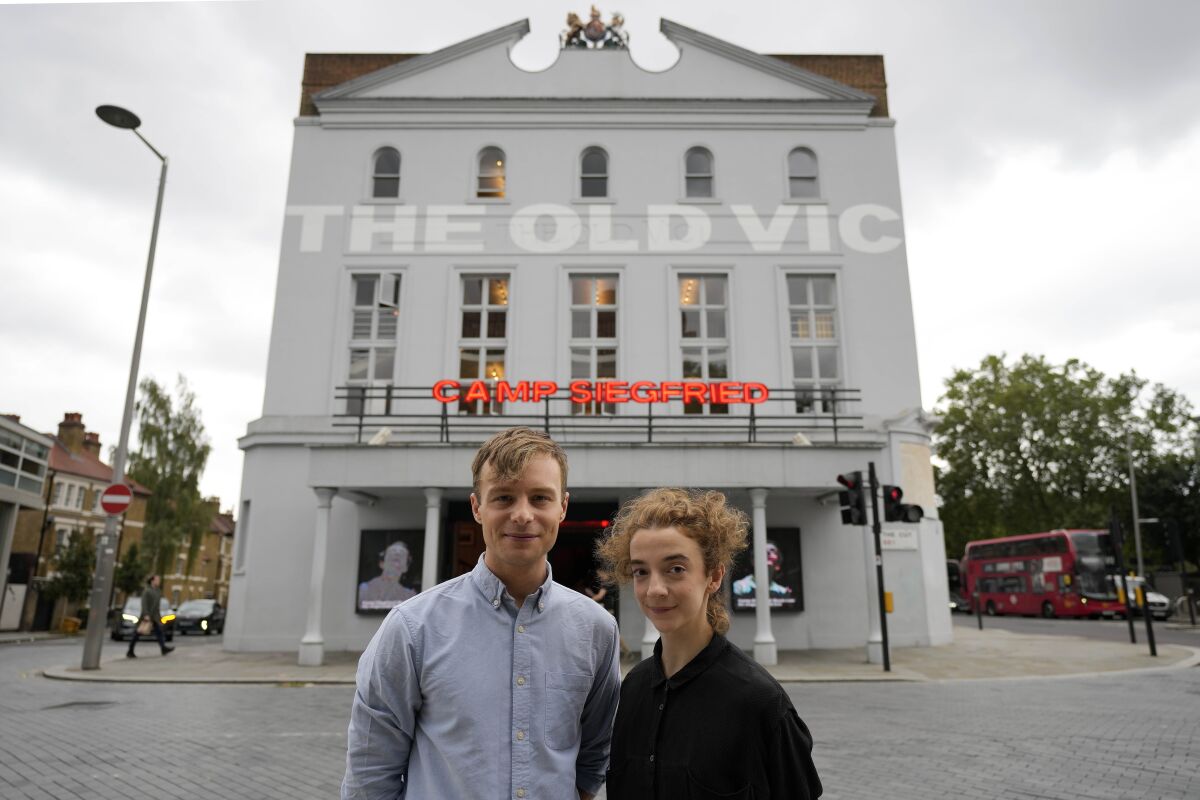 Actors Patsy Ferran, right and Luke Thallon, stars of the play Camp Siegfried, pose for a photographer in front of the Old Vic theatre in London, Friday, Sept. 10, 2021. London's Old Vic Theatre is reopening at full capacity for the first time since the pandemic began. The show is “Camp Siegfried,” American writer Bess Wohl's play about a summer camp for Nazis on New York's Long Island. It's based on a real-life camp in the 1930s that indoctrinated young German-Americans into the ideas of the Third Reich, and depicts two teenagers whose burgeoning relationship collides with the insidious ideology of Nazism. (AP Photo/Frank Augstein)