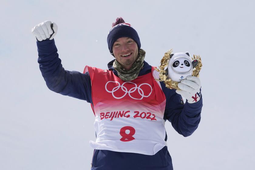 David Wise, who won silver, celebrates during the medal ceremony for the men's halfpipe at the Beijing Olympics.