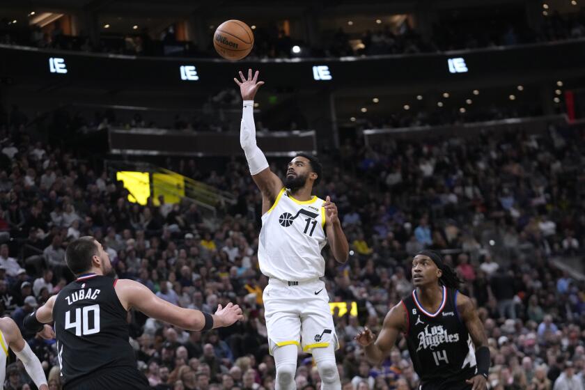 Utah Jazz guard Mike Conley (11) shoots as Los Angeles Clippers center Ivica Zubac (40) defends during the first half of an NBA basketball game Wednesday, Jan. 18, 2023, in Salt Lake City. (AP Photo/Rick Bowmer)