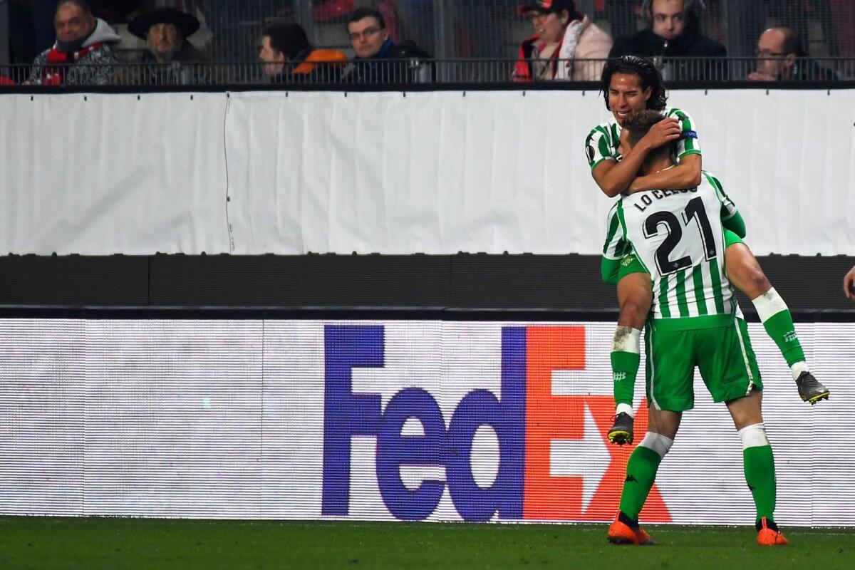 Real Betis' Spanish midfielder Diego lainez (top) celebrates with Real Betis' Spanish midfielder Giovanni Lo Celso after scoring a goal during the UEFA Europa League round of 32 first-leg football match between Rennes and Real Betis at the Roazhon Park stadium in Rennes, western France, on February 14, 2019.